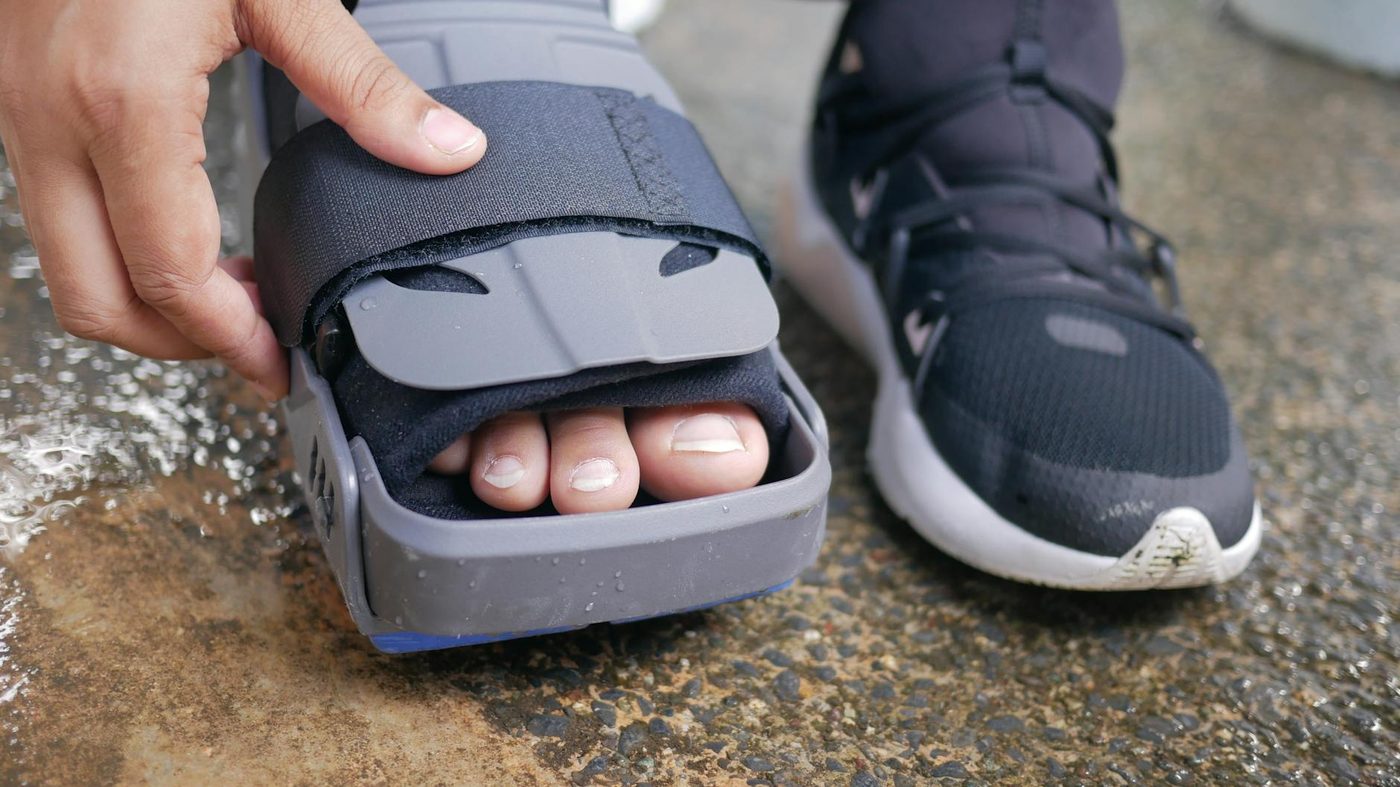 Foot and ankle support brace being adjusted during injury recovery
