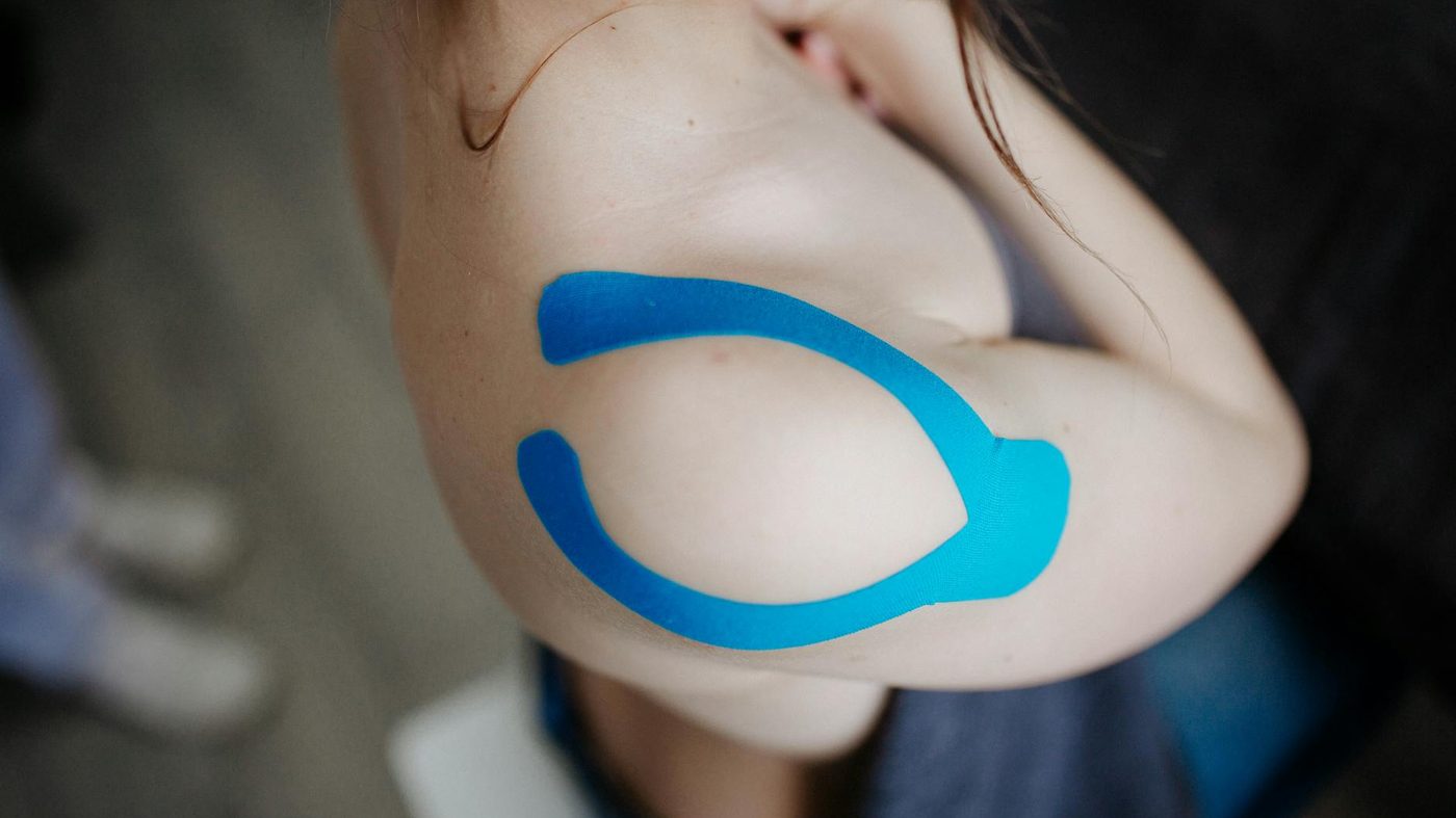 Shoulder support and taping during a physiotherapy-style recovery session