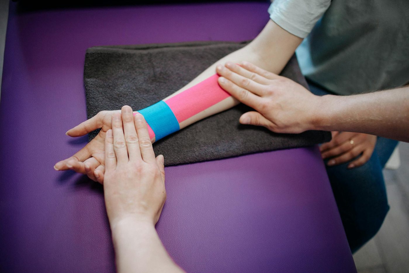 Therapist applying kinesiology tape to the forearm